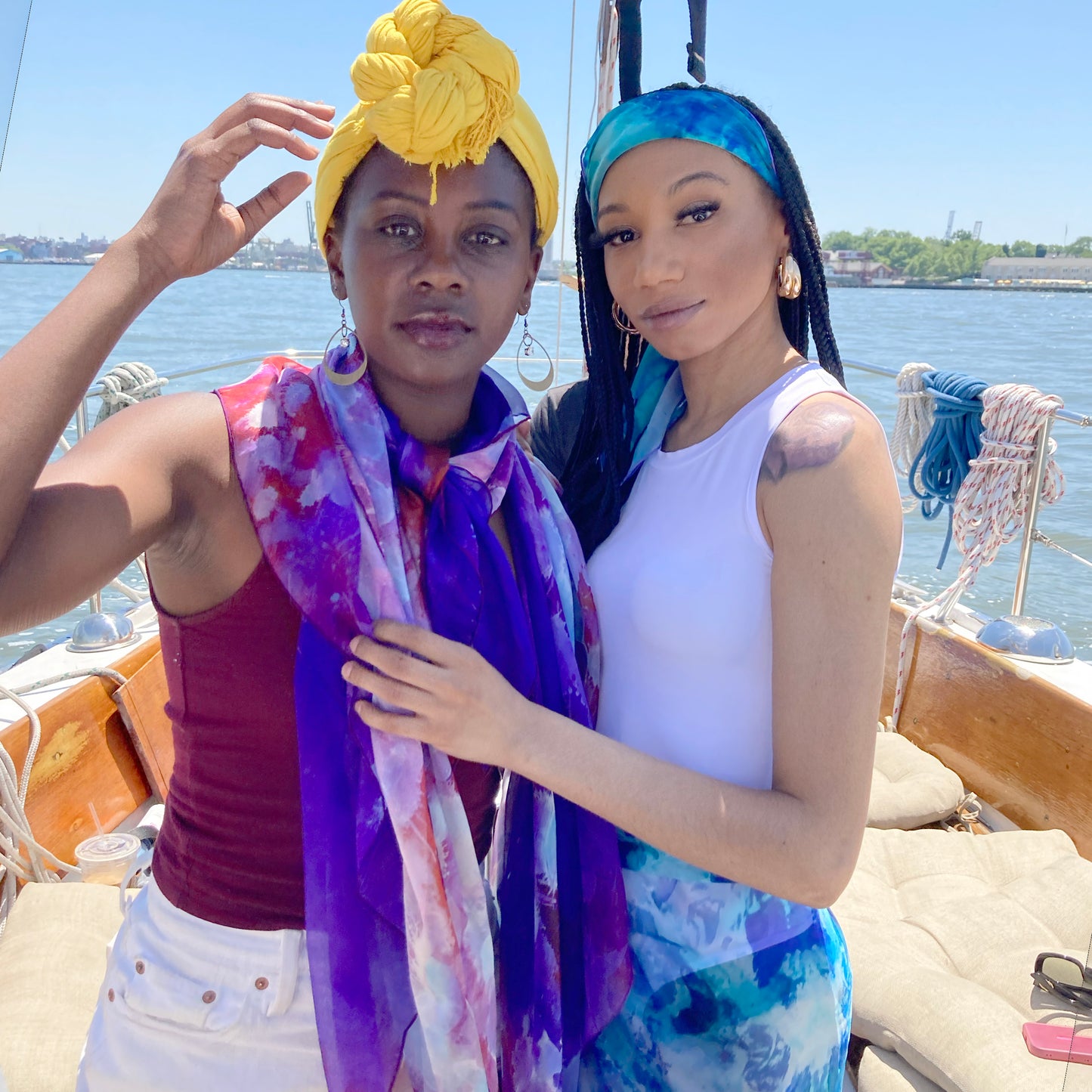 Two models wear silk chiffon scarves on a sailboat in the New York Harbor.