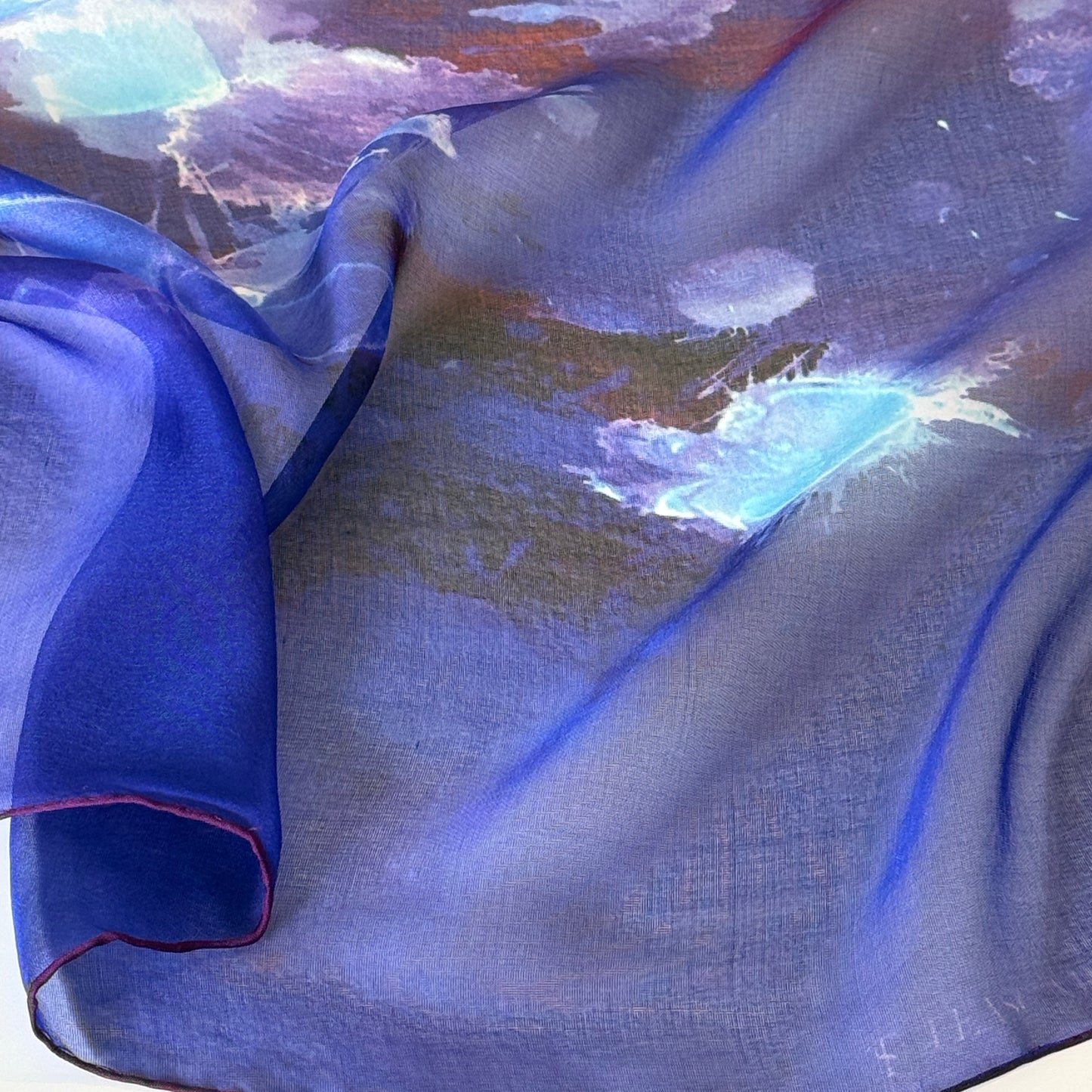 Close-up of 100% silk chiffon scarf in vibrant blue and red with hand-rolled and dyed in Love Symbol #2.