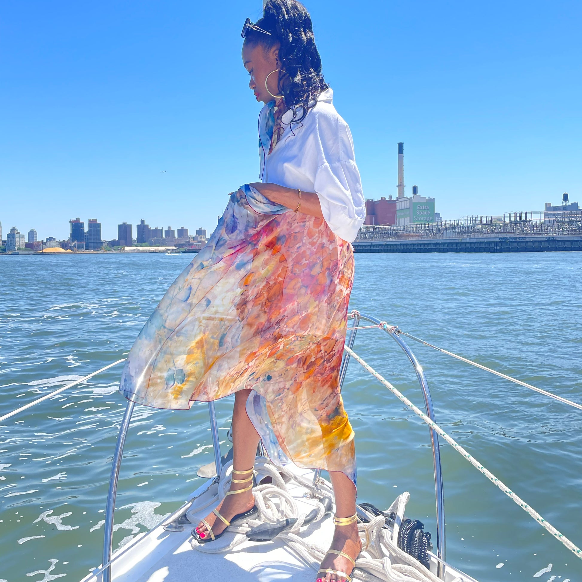 Professional scarf model on sailboat wearing an Oversized Rare Earth Scarf by Teascarf Brooklyn.