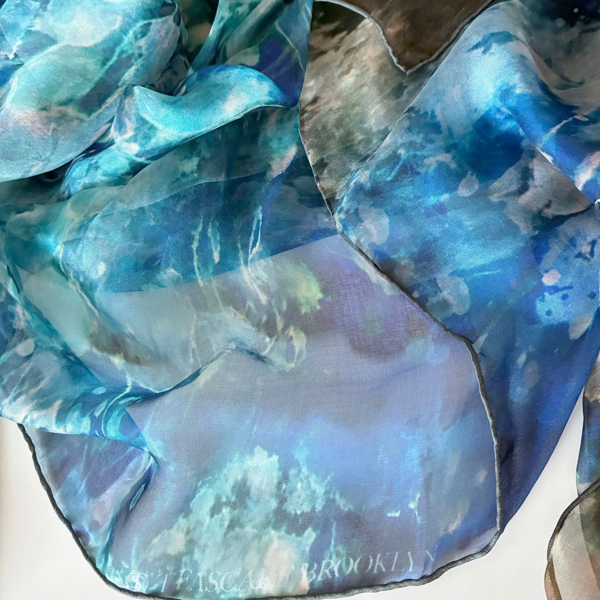 Detail of silk chiffon scarf with Teascarf Brooklyn branding.