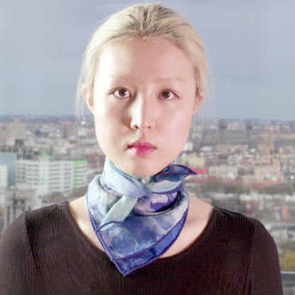 Model wears Small Clear Blue Scarf tied around her neck, simply tied.